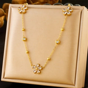Collier fleurs dorées avec strass sur présentoir